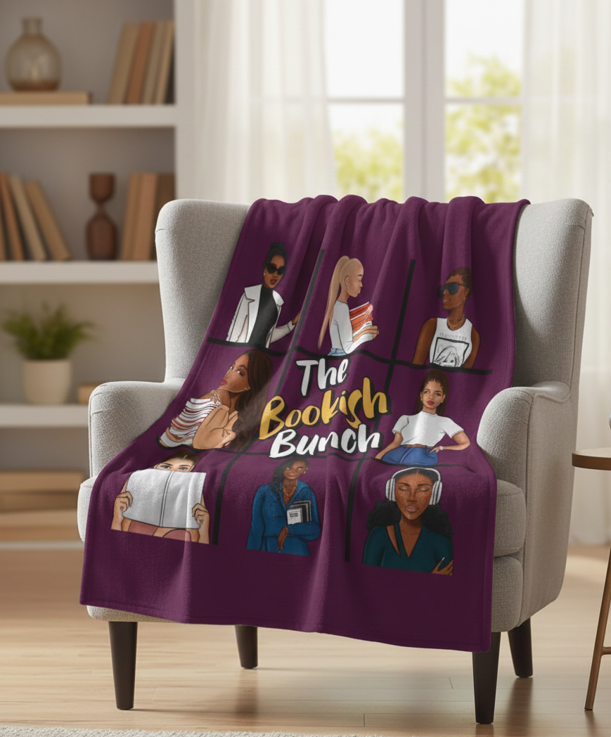 Purple blanket with illustrations and 'The Bookish Bunch' text draped over a chair in a room.